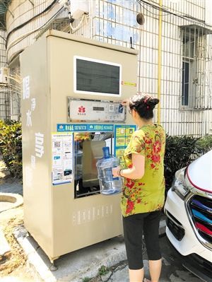 5月24日，瓊山區(qū)上丹花苑小區(qū)居民陳女士在使用共享凈水機(jī)取水。 本報(bào)記者 陳歆卓 攝